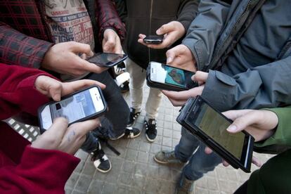 J&oacute;venes de un instituto barcelon&eacute;s consultan las redes sociales a trav&eacute;s del m&oacute;vil. 