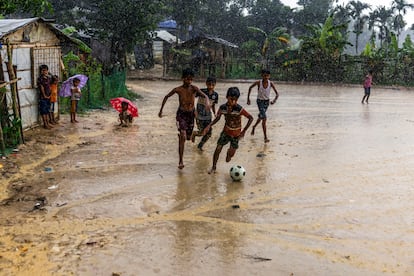 Unos niños juegan al fútbol bajo la lluvia del monzón en el campamento 4.
