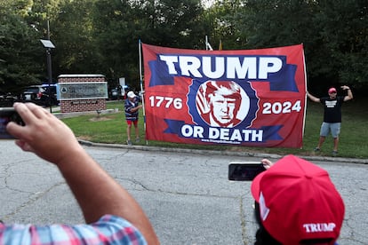 Manifestantes sostienen una pancarta en la entrada de la cárcel donde será procesado Trump. El expresidente negoció con sus abogados las condiciones de la entrega.