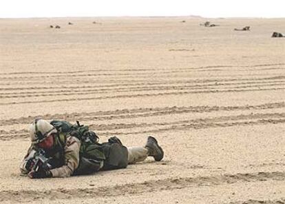 Un soldado estadounidense con la equipación de combate permanece cuerpo a tierra en una zona de maniobras cercana a la frontera con Kuwait.