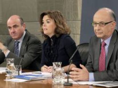 La vicepresidenta del Gobierno, Soraya Sáenz de Santamaría, y los ministros de Hacienda y Administraciones Públicas, Cristóbal Montoro (dcha), y Economía, Luis de Guindos, durante la rueda de prensa que ofrecieron hoy tras el Consejo de Ministros en la que se aprobó el proyecto de Presupuestos Generales del Estado para 2013.