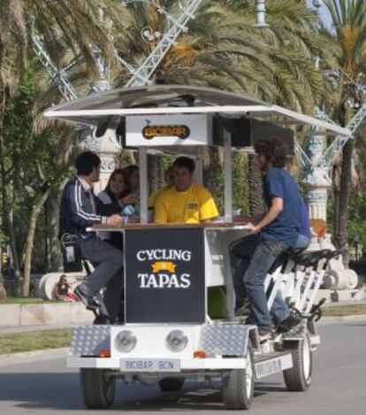 Unos turistas pasean por Barcelona sobre un 'bicibar'.