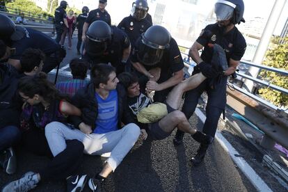 Una joven es desalojado por agentes de la policía durante el corte del tráfico en el puerte de Raimundo Fernández Villaverde de Madrid.
