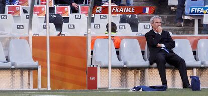 El seleccionador francés, Raymond Domenech, sigue en soledad, el calentamiento de su equipo  antes de empezar el partido frente a Sudáfrica.