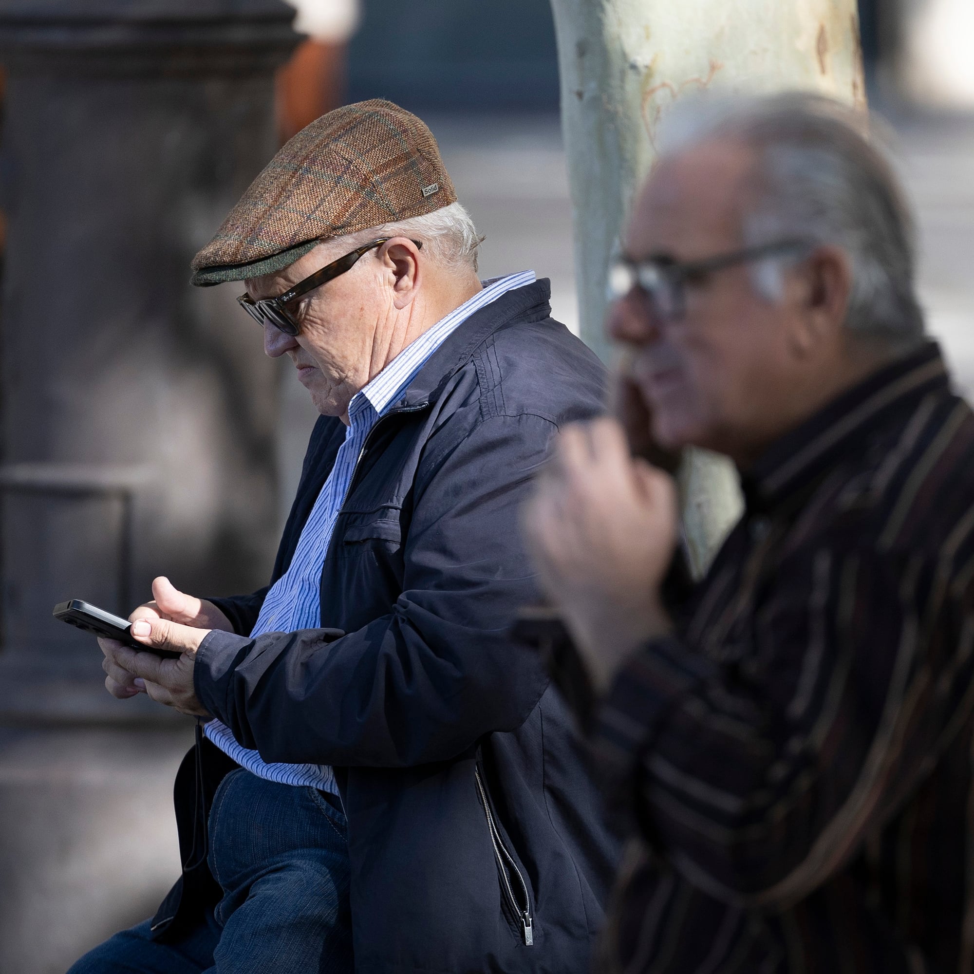 Un hombre mayor usa su teléfono móvil en Sevilla. 