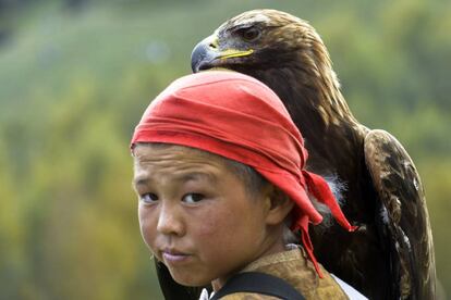 Un niño kirguís sujeta un águila real durante el segundo día de los World Nomad Games en el lago Issyk Kul de Cholpon-Ata (Kirguistán).