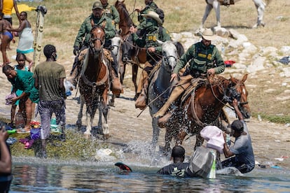 Agentes de frontera de EE UU intentan detener a un grupo de migrantes haitianos.