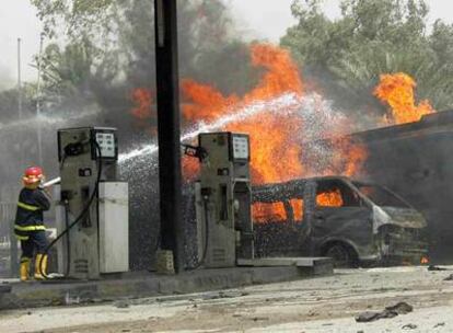 Los bomberos apagan el fuego de una camioneta bomba que explotó junto a una gasolinera ayer en Bagdad.