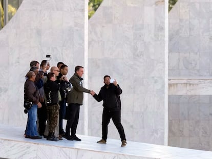 Bolsonaro cumprimenta apoiador depois de realizar mais uma 'motociata' em Brasília neste domingo.