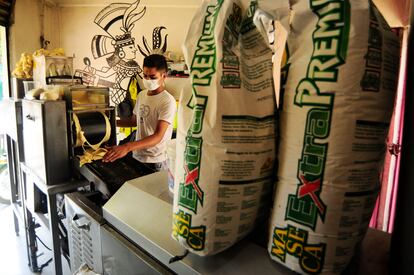 Un hombre coloca masa de maíz en una de las máquinas de una tortillería, en Ciudad de México.