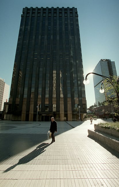 Un hombre pasea ante el edificio del Banco Santander en el cumplejo AZCA. Al fondo, la Torre Windsor.