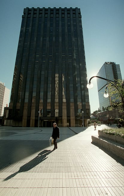 Un hombre pasea ante el edificio del Banco Santander en el cumplejo AZCA. Al fondo, la Torre Windsor.