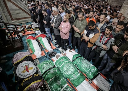 Palestinos asisten al funeral de las víctimas por los ataques aéreos israelíes, este martes.