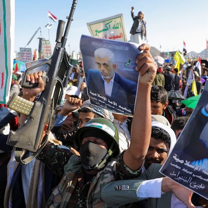 A person holds a weapon and a sign showing the late Hamas leader Yahya Sinwar as protesters, mainly Houthi supporters, rally to show support to Lebanon's Hezbollah and Palestinians in the Gaza Strip, in Sanaa, Yemen October 18, 2024. REUTERS/Khaled Abdullah