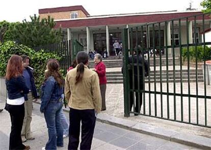 Un grupo de estudiantes espera a las puertas del instituto en la calle de Antonio Leyva de Carabanchel, donde ha ocurrido el suceso.