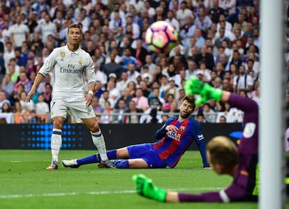 Cristiano Ronaldo, dispara al lado del defensa del Barcelona, Gerard Piqué.