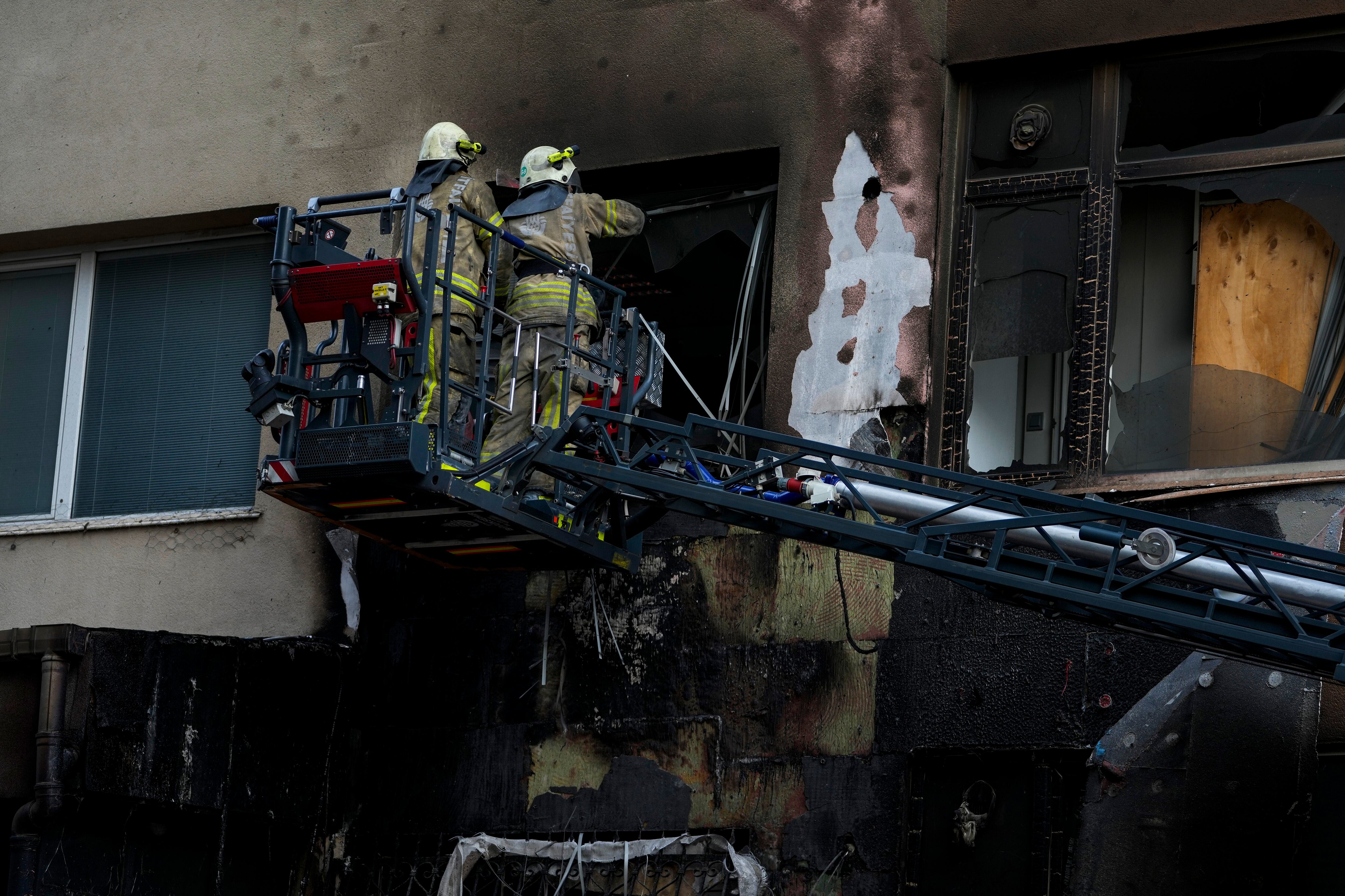Los bomberos trabajan en el edificio incendiado durante unas obras sin permiso en Estambul, este martes.