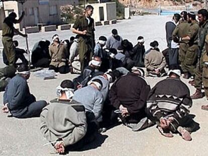 Prisioneros palestinos, con los ojos vendados y maniatados, en una plaza de Hebrón tras la incursión del Ejército israelí.