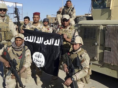 Soldados iraquianos exibem uma bandeira do Estado islâmico na província de Anbar.
