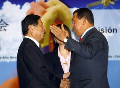 El presidente venezolano, Hugo Chávez, saluda al ministro de la Comisión Nacional de Reforma y Desarrollo de China, Zhang Ping.