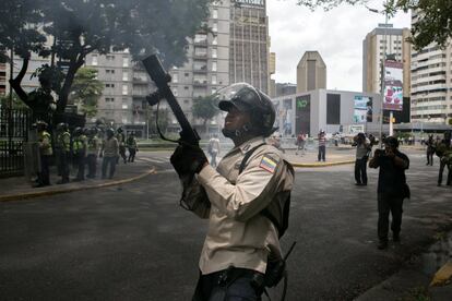 Um grupo de policiais lança gás lacrimogêneo para dispersar os manifestantes que tentavam chegar à sede do Centro Nacional Eleitoral, em Caracas, Venezuela.