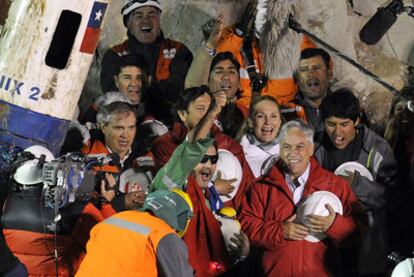 El líder de los mineros, Luis Arzúa, con el brazo en alto, canta junto al presidente de Chile, Sebastián Piñera, el himno nacional poco después de ser rescatado. Fue el último en salir.