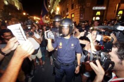 Un policía graba una de las consignas de los manifestantes.