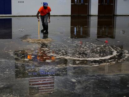 Un trabajador aparta el agua de un gimnasio en Houston, Texas, tras el paso de la tormenta Harvey.