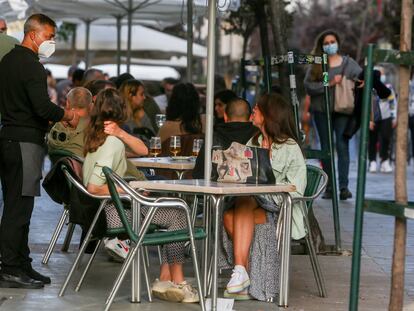 Un camarero atiende a unas clientas en una terraza de Madrid a principios de abril.