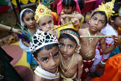 Niños hindúes vestidos como el dios Krisna se preparan para el concurso de disfraces que tiene lugar durante la celebración del Janmashtami, en Hyderabad (India).