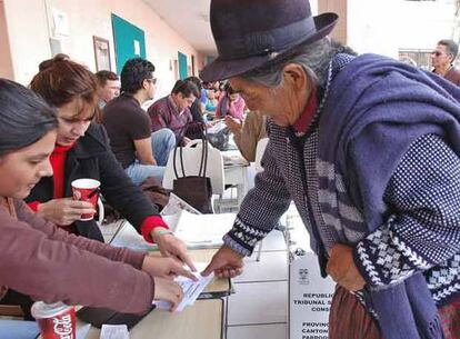 Una mujer deposita su voto en un colegio electoral de Quito.