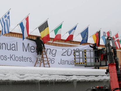 Dos operarios trabajan preparando el centro de congresos de Davos donde se celebrará el Foro Económico Mundial