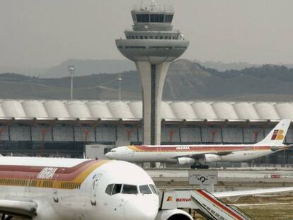 Vista de un avión de Iberia y la torre de control del aeropuerto Madrid-Barajas Adolfo Suárez.