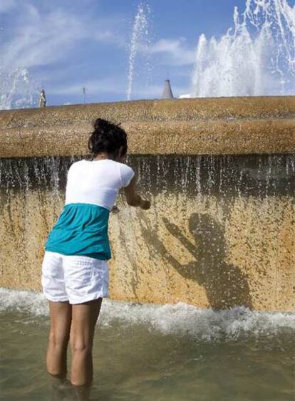 Una joven se refrescaba, ayer, en la plaza de Catalunya.