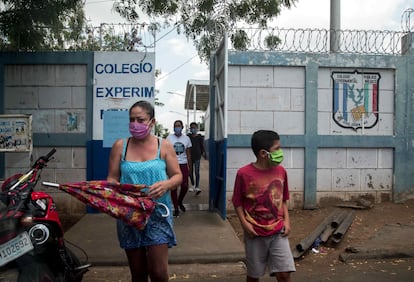 Una mujer junto a su hijo con mascarilla salen de una escuela pública en mayo de 2020, en Managua (Nicaragua). La Unidad Sindical Magisterial de Nicaragua denunció que los maestros nicaragüenses con síntomas de covid-19 no tenían acceso a las pruebas PCR, mientras las clases seguían sin ser suspendidas.  