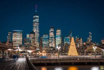 Vista de Manhattan desde Nueva Jersey, con un árbol navideño iluminado en primer plano.