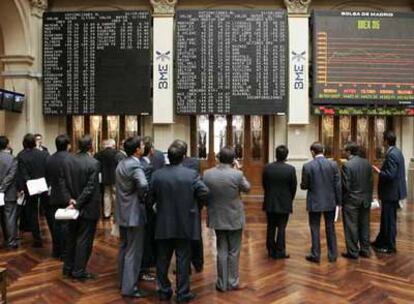 Un grupo de inversores observa el panel de cotizaciones en la Bolsa de Madrid.