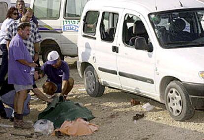 Un grupo de israelíes, junto al cadaver de la mujer asesinada hoy en Cisjordania.