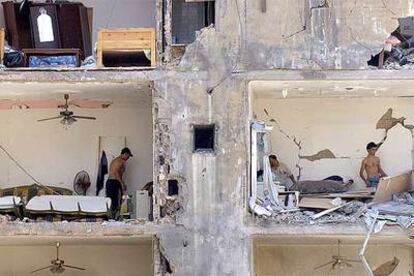 Varias personas examinan los daños causados por los bombardeos israelíes en sus viviendas en uno de los suburbios del sur de Beirut.
