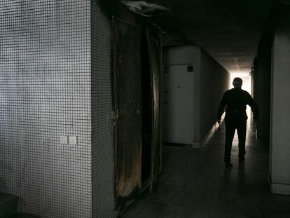 Un vecino ante el cuadro eléctrico donde se produjo el incendio en un bloque de pisos públicos en el Raval de Barcelona.