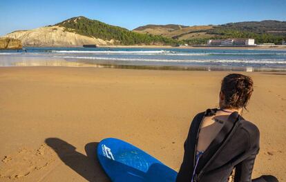 Una surfista descansa en la playa de Gorliz, en Bizkaia.