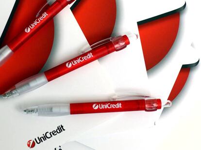 Logo de Unicredit en un cuaderno y bol&iacute;grafos de la empresa.