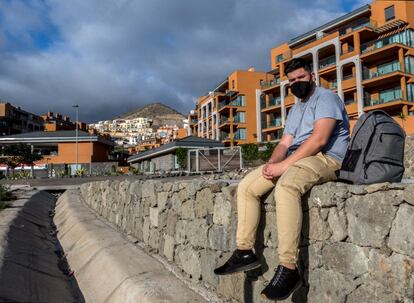 Yassine El Assire, de 23 años, posa con sus pertenencias en la calle frente al hotel Arguineguín Park, Gran Canaria, donde le fue negada la entrada tras ausentarse varios días para intentar viajar a la Península.