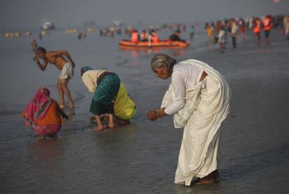 Devotos indios realizan rituales tras un baño, en la bahía de Bengala, en la isla Sagar (India).