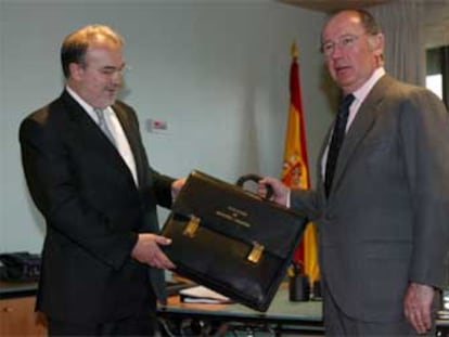 Pedro Solbes (izquierda) recibe de Rodrigo Rato la misma cartera que ya se habían intercambiado en 1996.