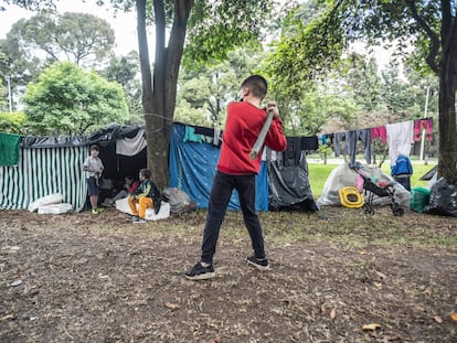 Un niño practica béisbol en un campamento improvisado por migrantes venezolanos, en Bogotá.