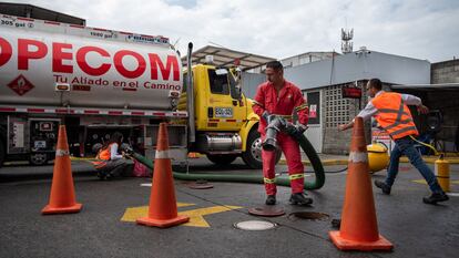 Trabajadores depositan gasolina en una estación de servicio en Cali (Colombia), en junio de 2023.