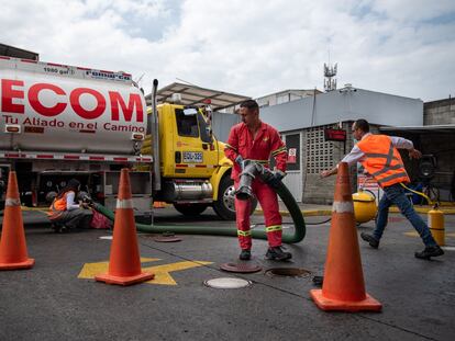 Trabajadores de una estación de gasolina abastecen los tanques de combustible, en Cali, el 8 de junio de 2023.