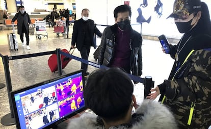 Passageiros passam por controle sanitário no aeroporto de Wuhan, na China.