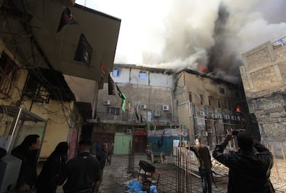 Unas personas contemplan las llamas de un edificio tras un atentado en Bagdad (Irak).